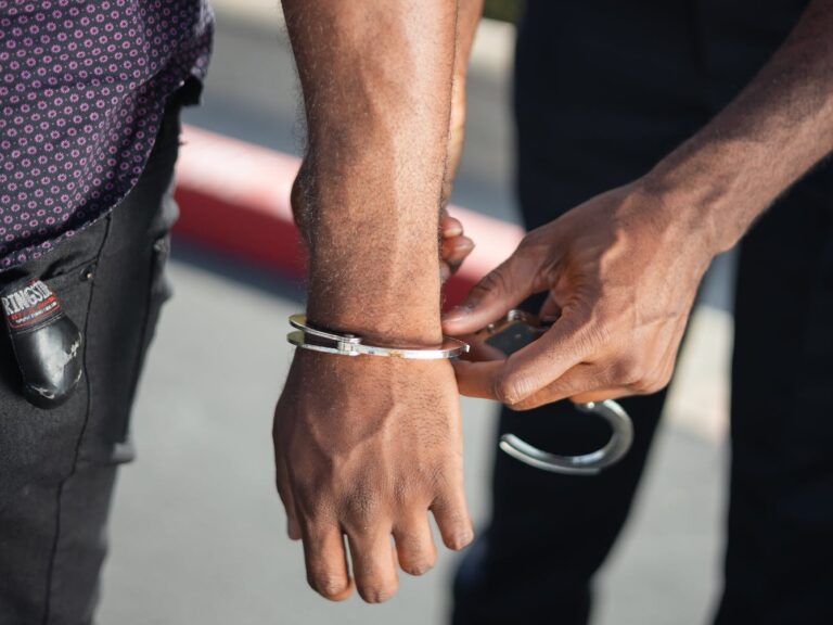 police officer putting handcuffs on another person