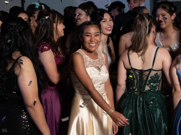 teenage boys and girls in evening dresses at a prom party