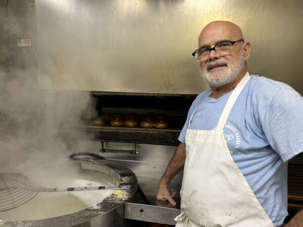 bagel maker stands next to steaming vat