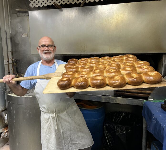 baker with tray of bagels