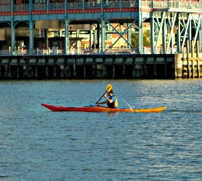 kayaker_ past_pier kayaker on river